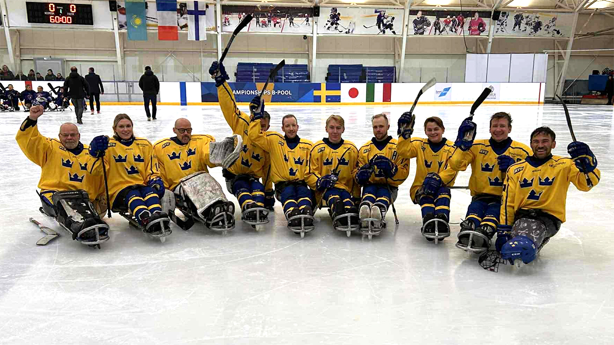 Gruppbild på de svenska spelarna som står uppradade på isen och höjer sin klubbor i luften.