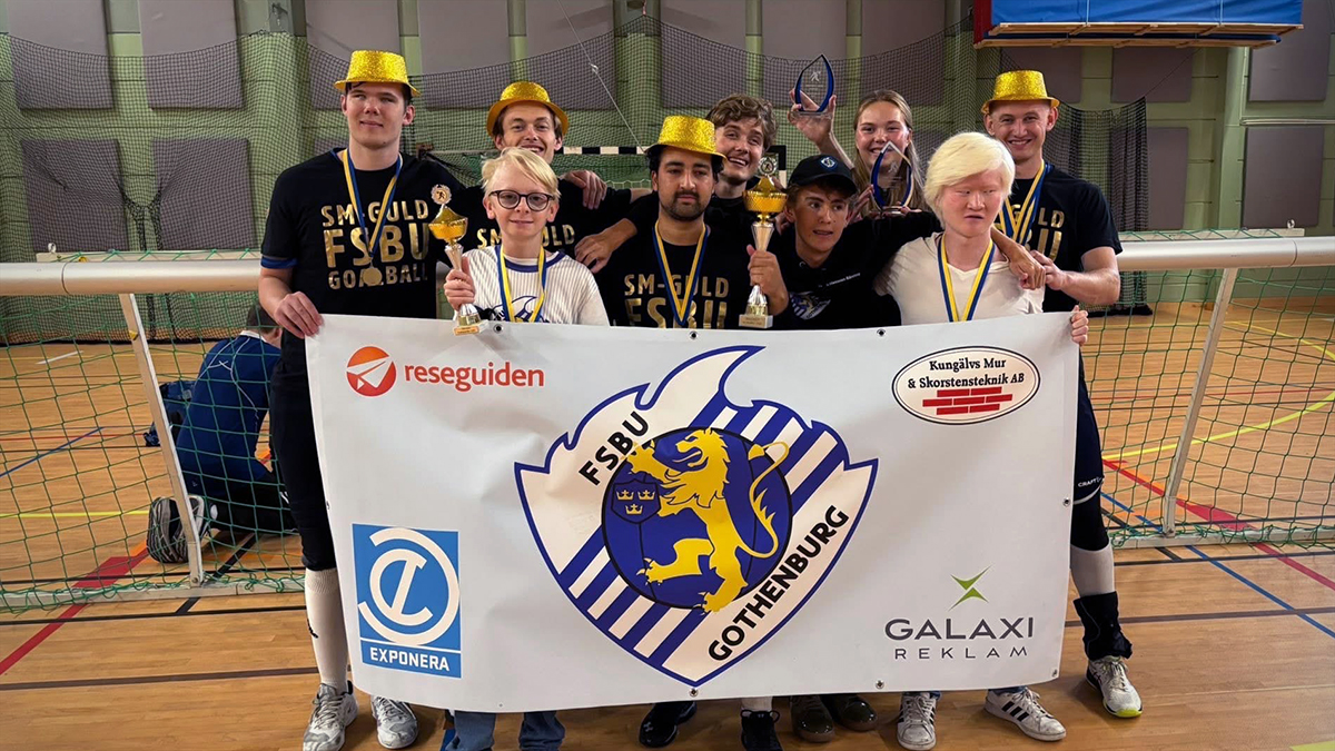 Gruppbild på FSBU som firar SM-guldet i guldhattar. De håller en FSBU-flagga framför sig.