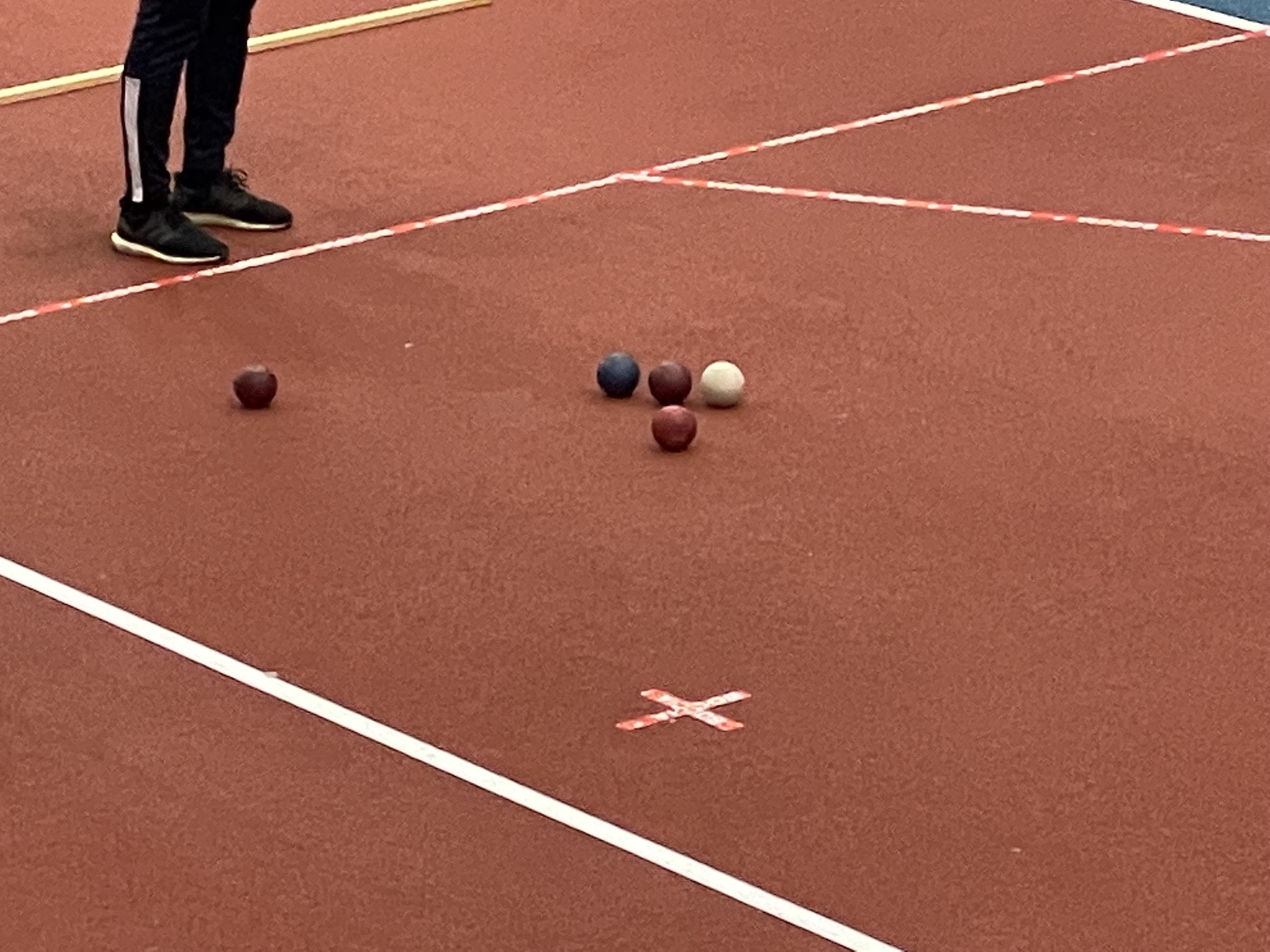 Bild på ett flertal boccia bollar som ligger samlade. De är röda och blå.