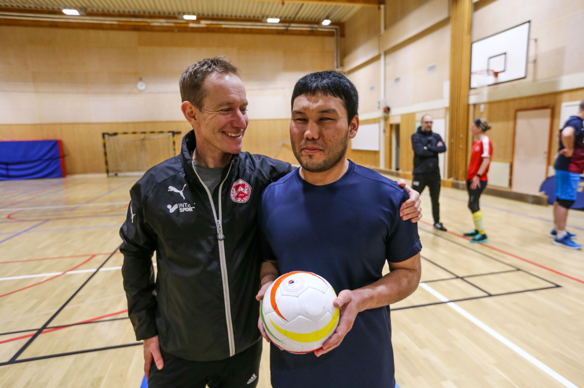 En ledare tillsammans med en utövare i fotboll 5-a-side.