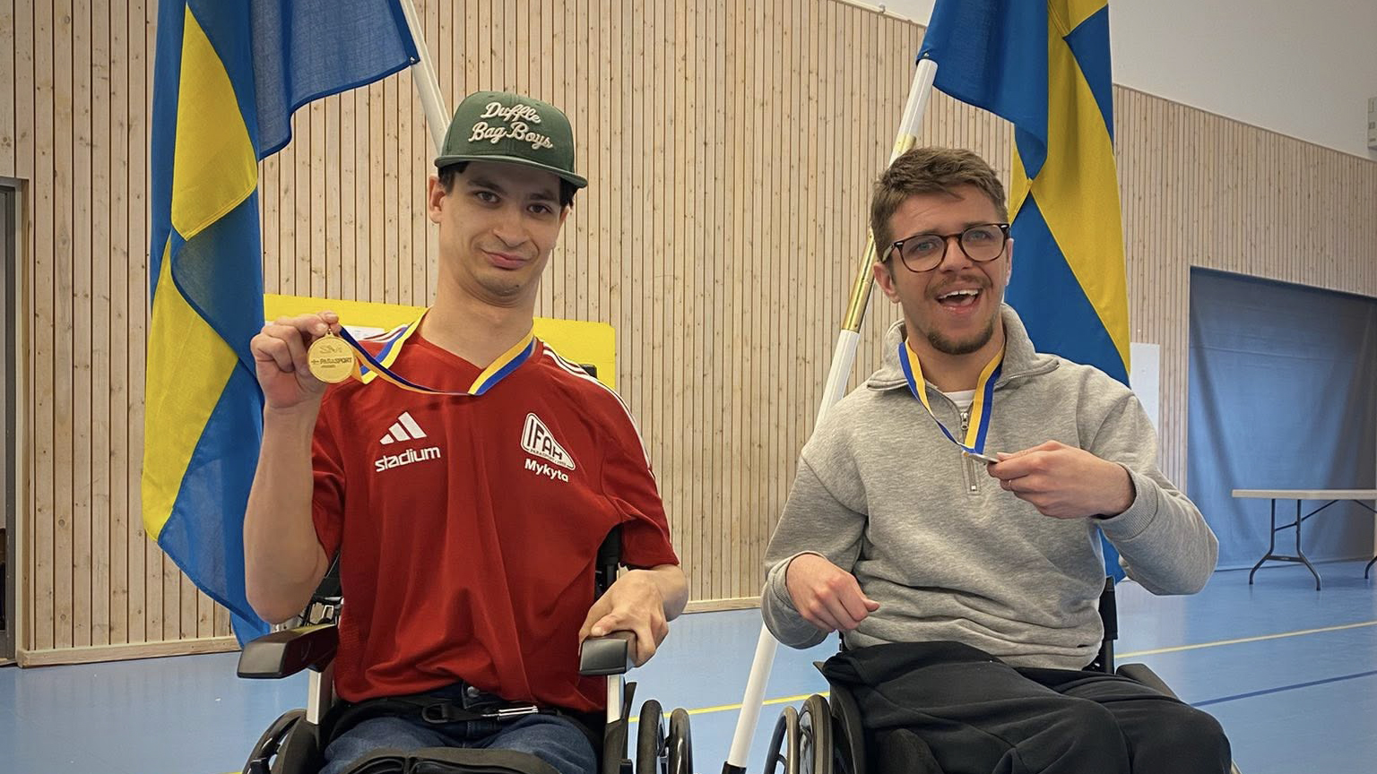 Två spelare visar stolt upp sina medaljer.