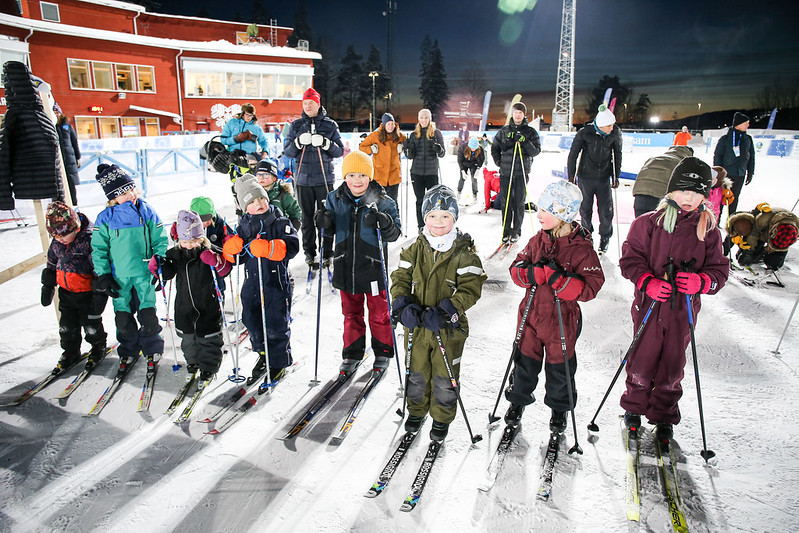 Många förväntansfulla barn väntar på starten i ett skidlopp.