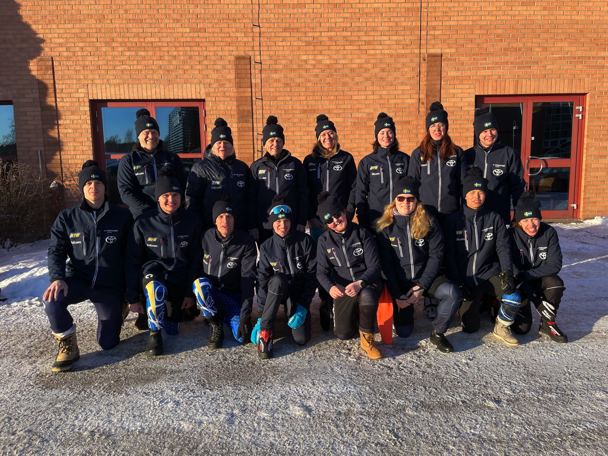 Gruppbild på den svenska truppen till Virtus-VM i Seefeld som har ställt upp sig framför en tegelvägg.