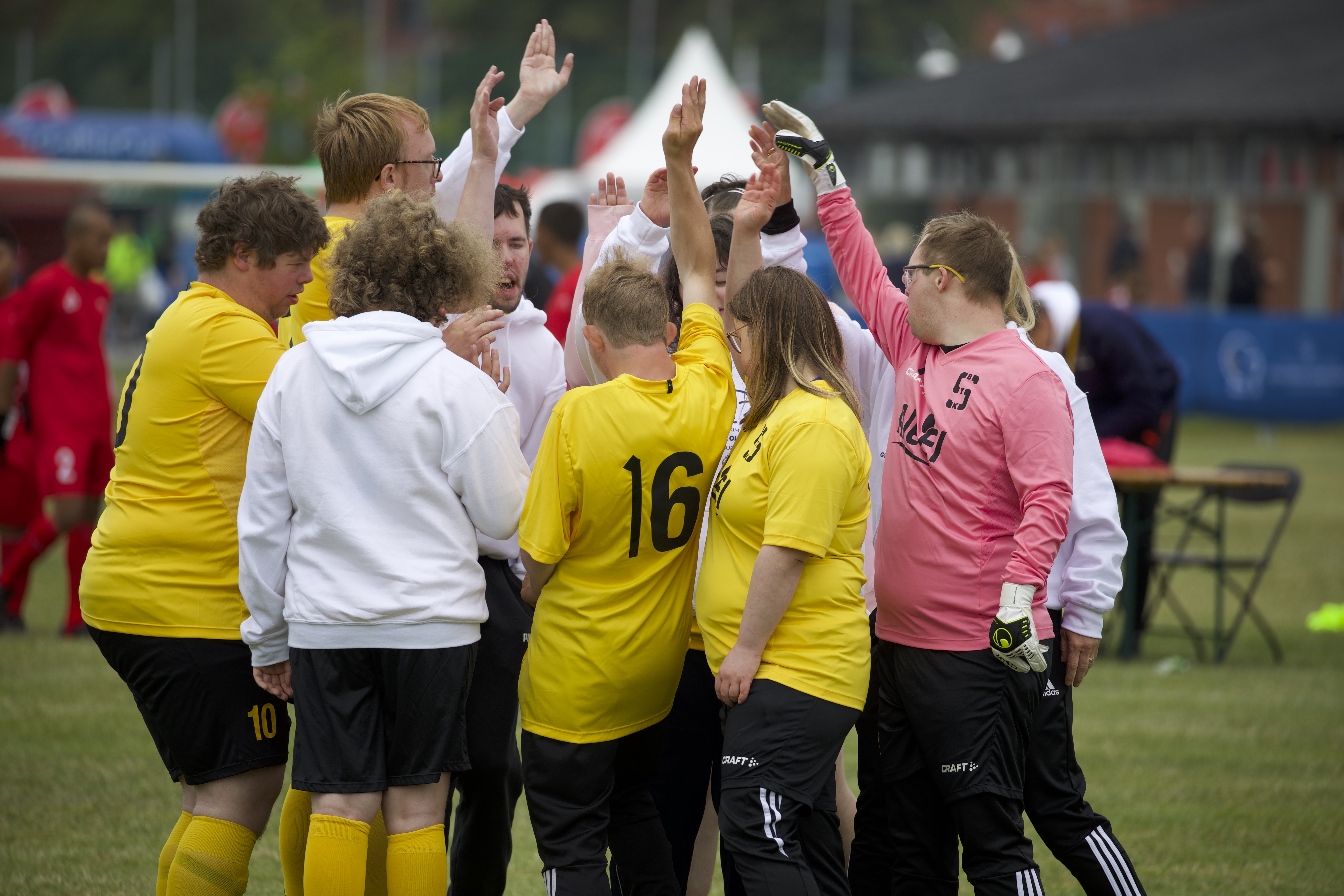 Glada fotbollsspelare som står i en ring på fotbollsplanen