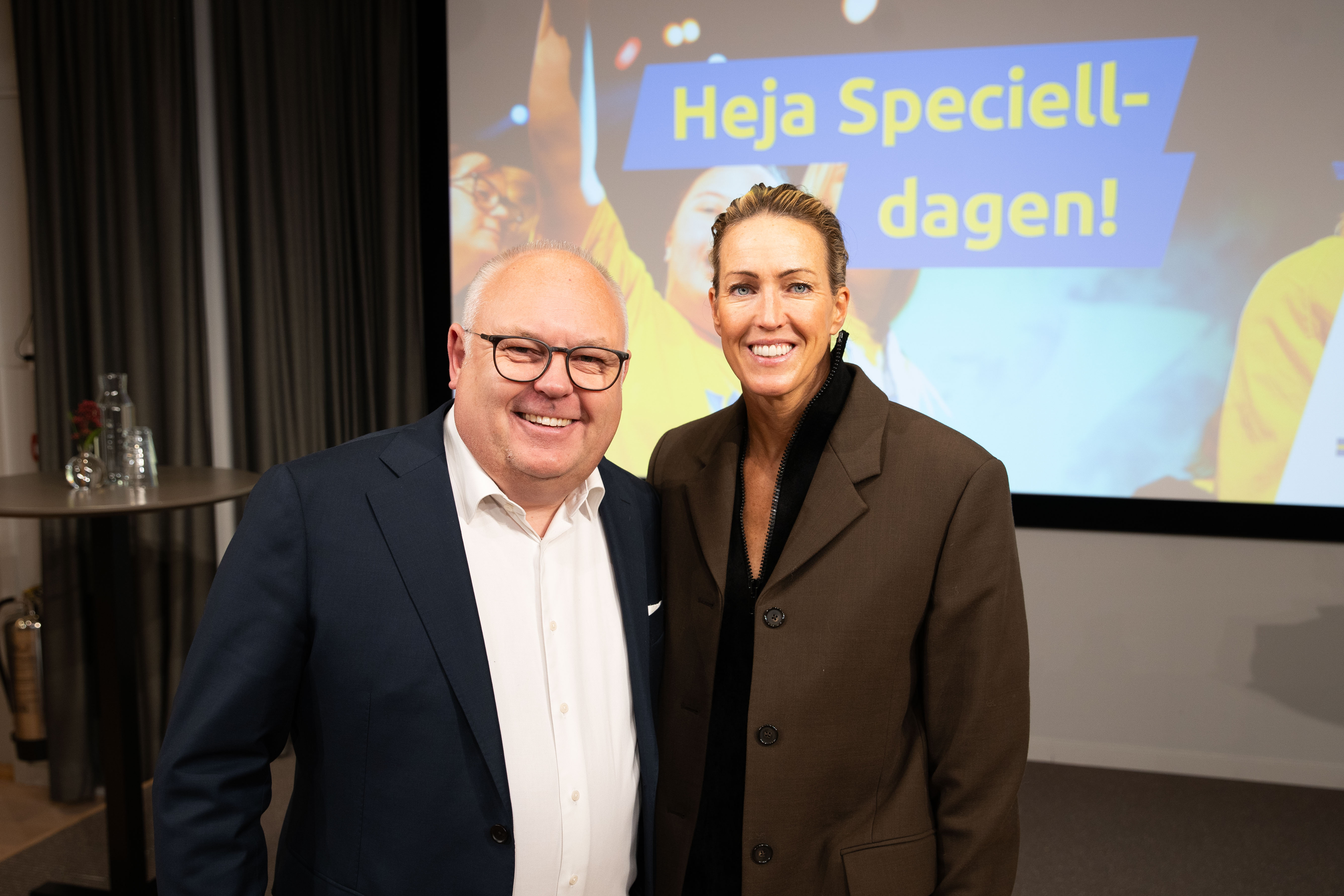 Inomhusmiljö, konferensrum. Lasse Persson och Therese Alshammar sida vid sida framför en projektorduk.