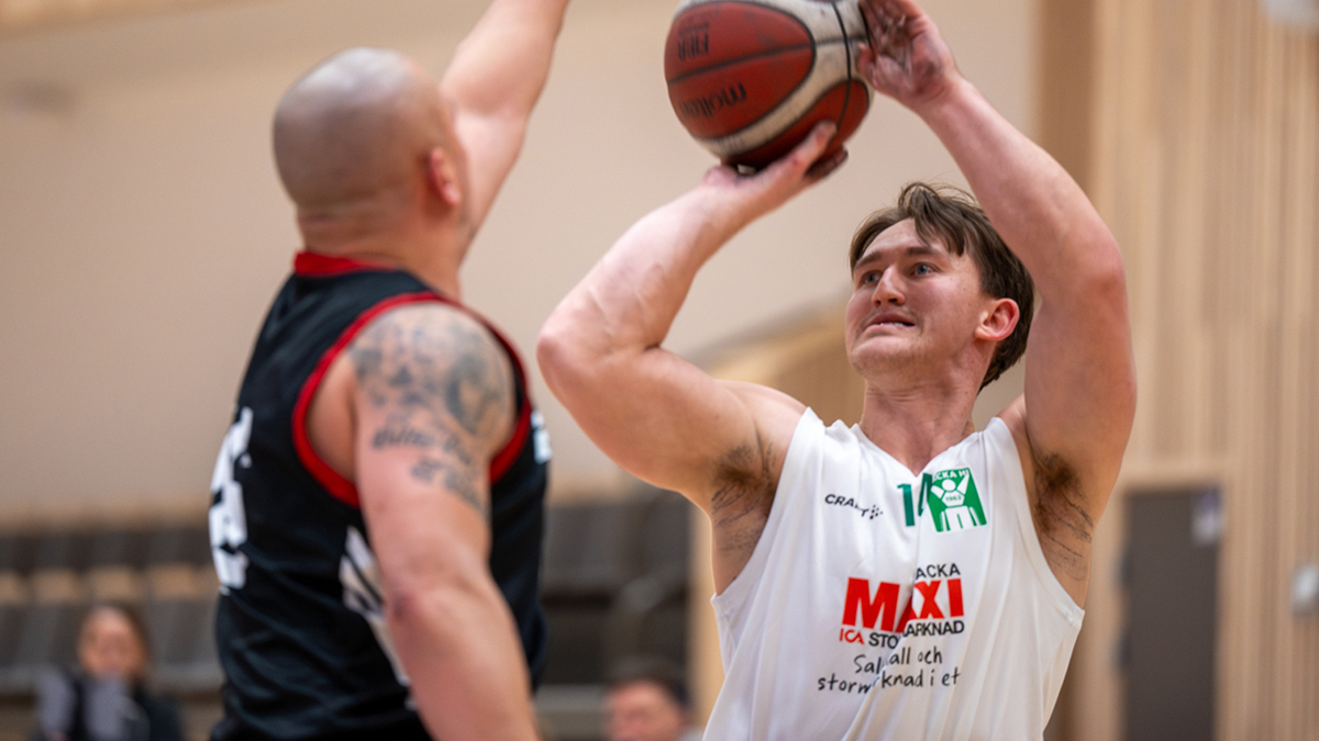 Två rullstolsbasketspelare tampas om bollen.