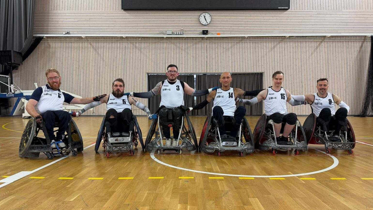 Gruppbild på de sex spelarna i Köping Hillbillies. Spelarna bär vita matchtröjor med svarta detaljer.