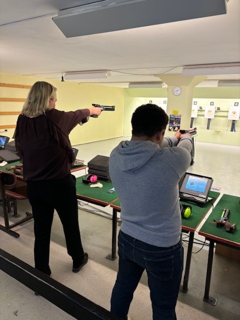Två personer skjuter med pistol.