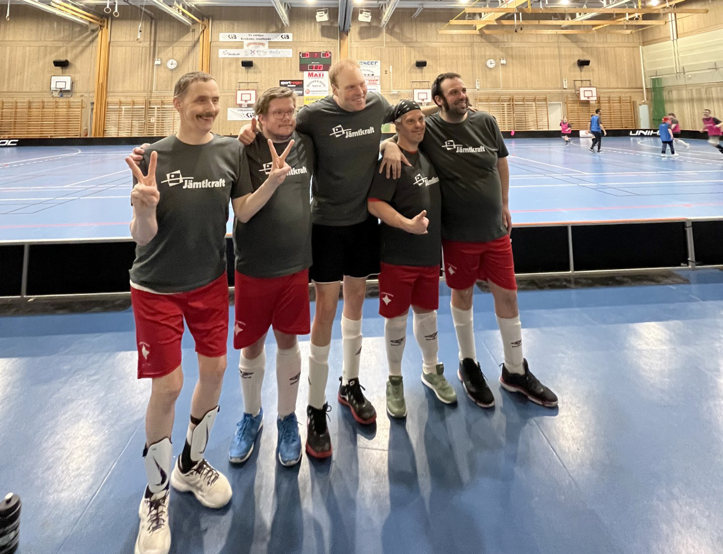 Fotbollscup 2025, ett lag som stoltserar framför pågående match i bakgrunden