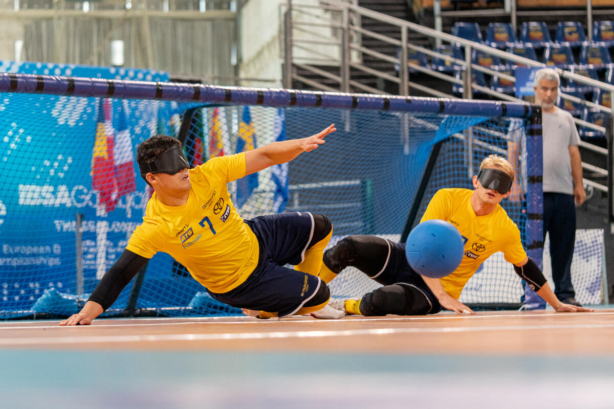 två spelare i goalball försvarar målet mot ett skott