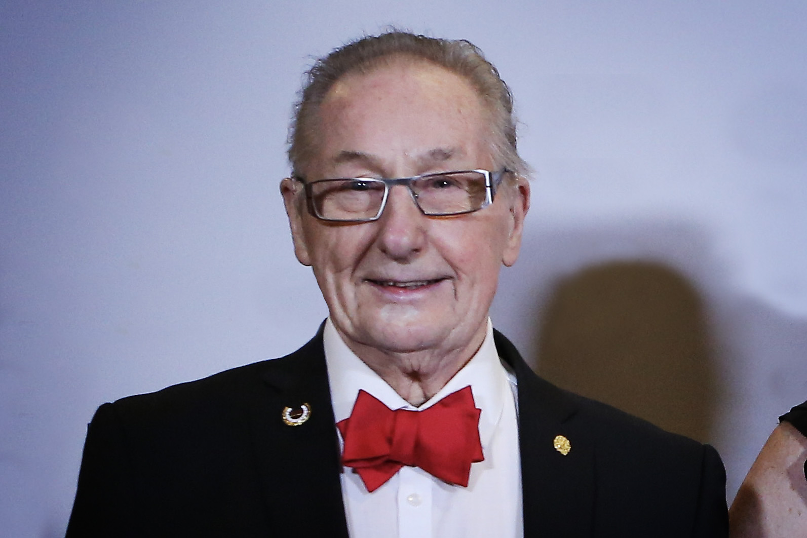 Hans Lindström i svart kostym, röd fluga och glasögon.