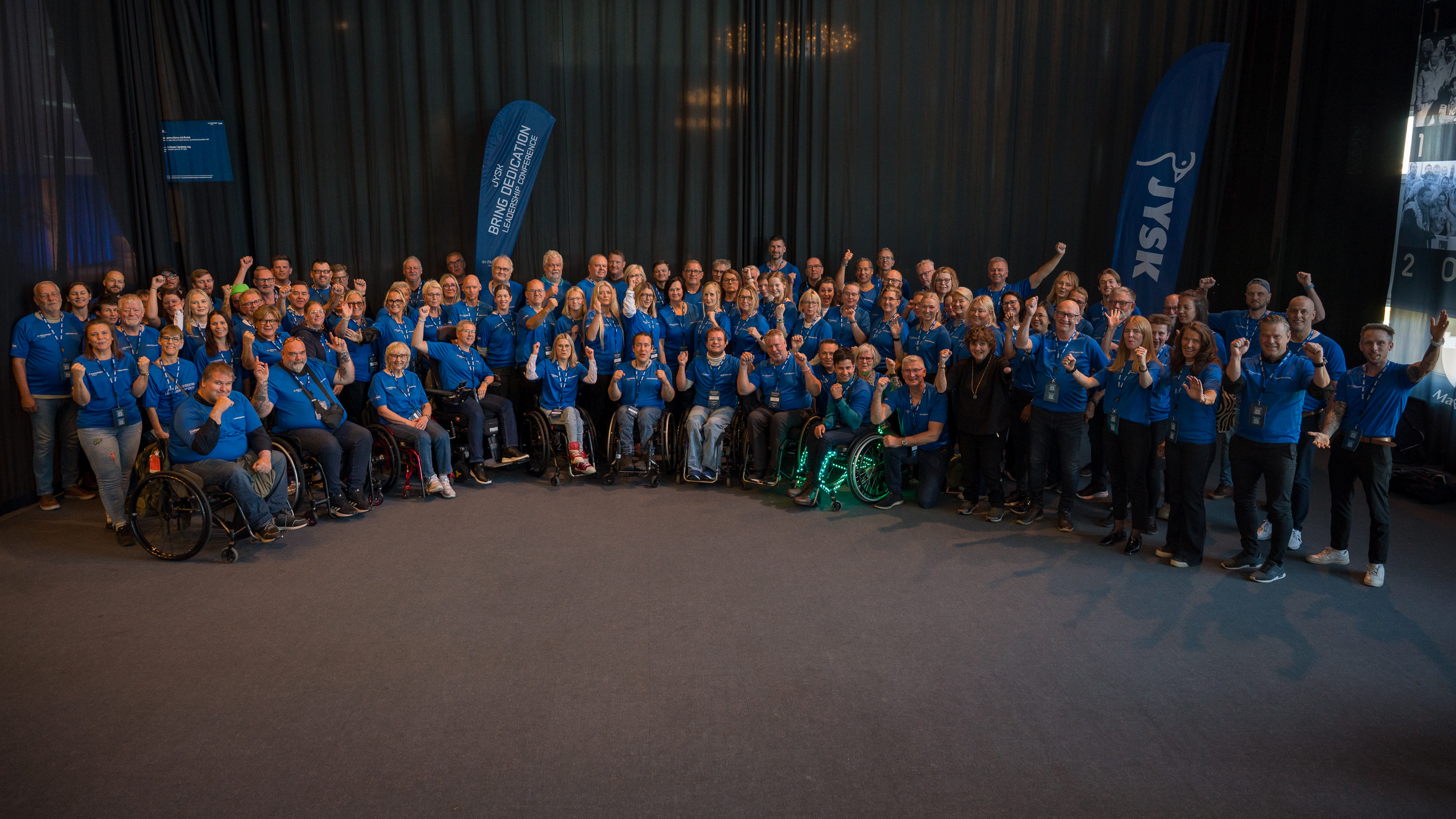 Gruppbild på en majoritet av konferensens deltagare. Alla bär blå t-shirts.